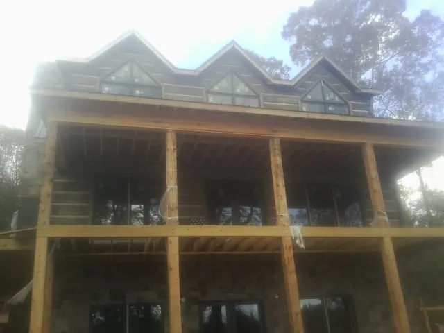 Dormers and porch framing on a large log home under construction in Brownsville